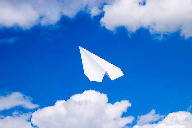 istock White paper airplane in a blue sky with clouds. The message symbol in the messenger 950819792