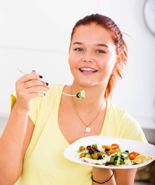 istock girl eating salad 950827366