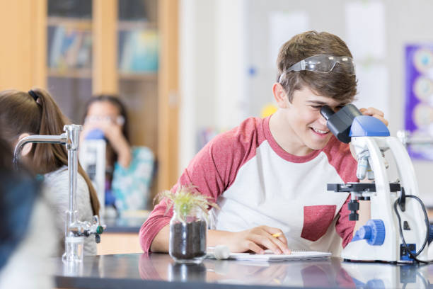 istock Teenage boy uses microscope to analyze soil sample 950832054