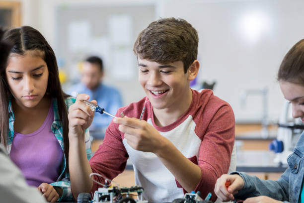 istock Teen enjoys building robot in engineering club 950832108