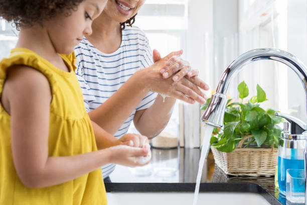 istock Little girl concentrates while washing hands 950832572
