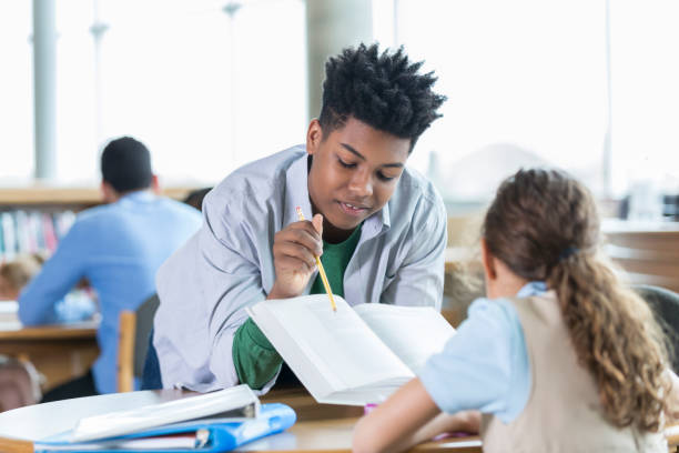 istock Teenage boy tutors elementary student 950832738