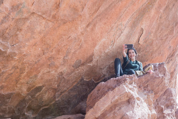 istock Young woman takes selfie on rocky ledge 950832836