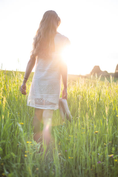 istock Young girl walking in high grass field 950836672
