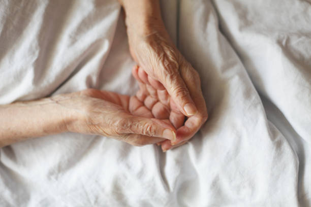istock Opened senior hands asking for something. Old woman in bed. 950839240