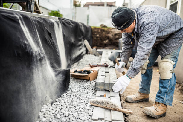 último homem reconstruindo uma parede de retenção - stone paving stone patio driveway - fotografias e filmes do acervo