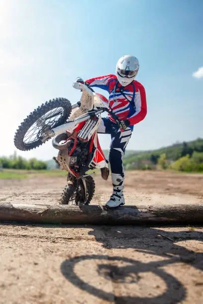 Hard enduro motorcycle rider crossing logs on an obstacle course. Extreme outdoor sports.