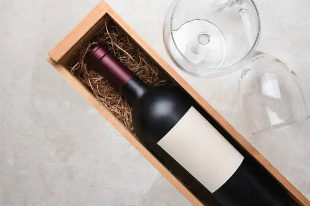 Cabernet Sauvignon: A bottle in wood case with glasses and copy space.