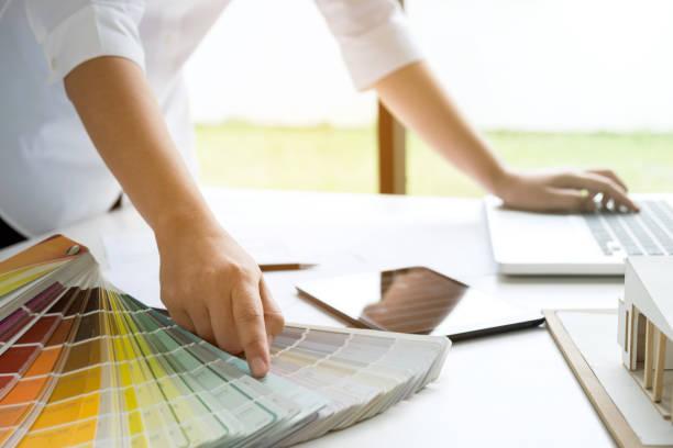 istock interior design or graphic designer working on project of architecture drawing with work tools and color swatches, colour chart in digital tablet at workplace 950844462