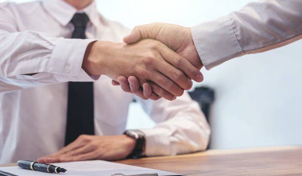 istock Real estate broker agent and customer shaking hands after signing contract documents for realty purchase, Bank employees congratulate, Concept mortgage loan approval 950844638