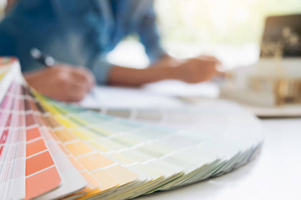 istock Two interior design or graphic designer at work on project of architecture drawing with work tools and color swatches, colour chart, color samples for selection, renovation and technology concept 950844692