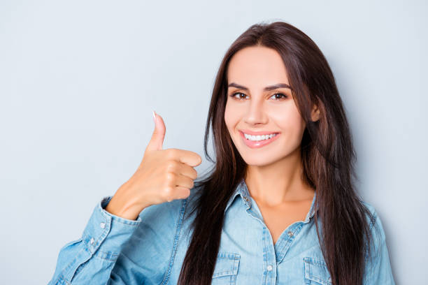 istock Pretty woman with beaming smile showing thumb up 950845610