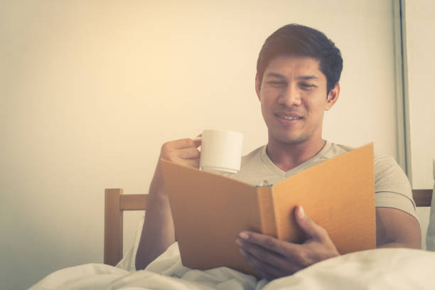 istock Asian male is studying and drink coffee on morning bed 950850984