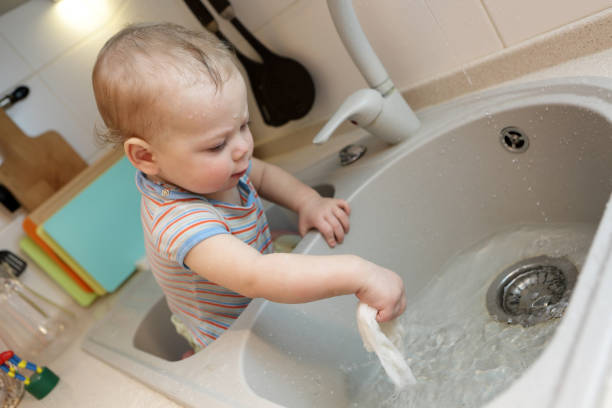 istock Baby sitting in the kitchen sink 950853832
