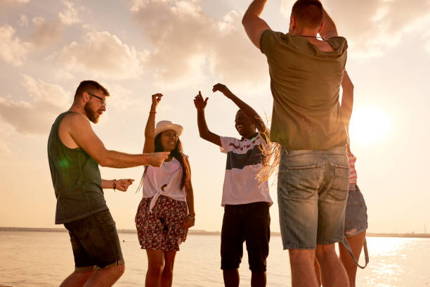 istock Excited multiethnic friend dancing on coastline 950854402