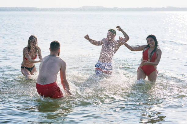 istock Ecstatic friends splashing lake water 950854418