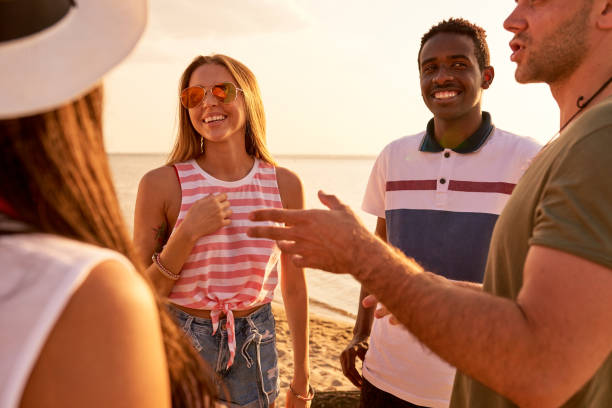 istock Positive young friends chatting on beach 950854422