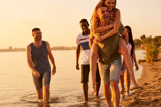 istock Cheerful friends walking together over coastline 950854476