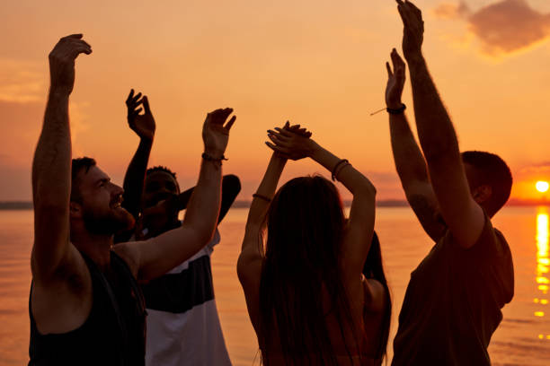 istock Ecstatic young students enjoying beach party at sunset 950854500