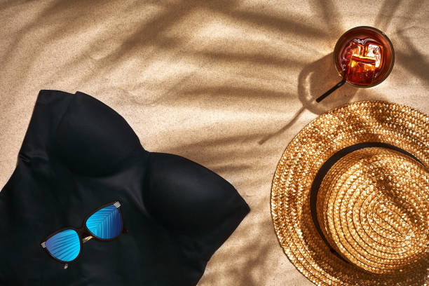 istock Women's beach accessories or summer outfit on sand background. Top view with copy space 950854582