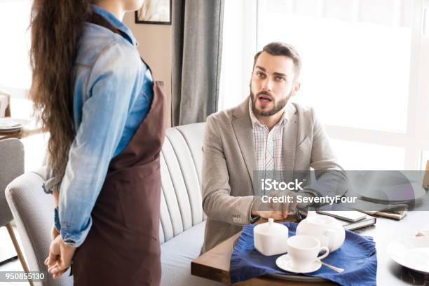 Pensive Customer Asking Waitress In Cafe Stock Photo - Download Image Now - Asking, Waitress, Adult
