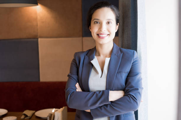 Cheerful successful female restaurateur Happy cheerful confident attractive young Hispanic female restaurant manager crossing arms on chest and smiling at camera in cafe restaurateur stock pictures, royalty-free photos & images