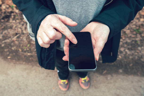 istock Close up of female hands using smartphone outdoor 950856424