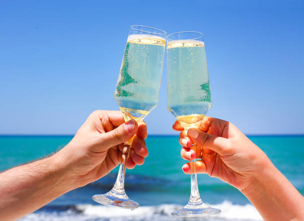 istock Two champagne glasses in man and woman hands 950856538
