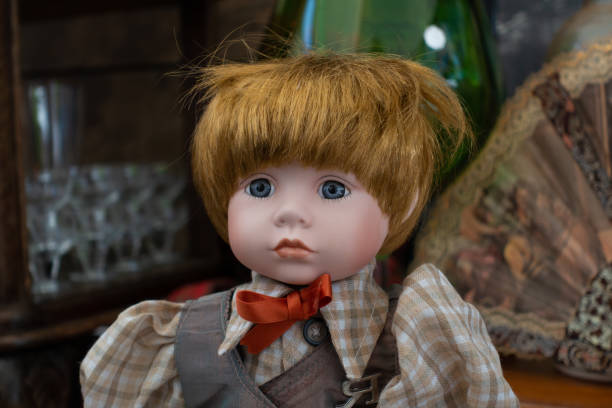 cute vintage boy doll with checkered shirt and red bow tie on flea market