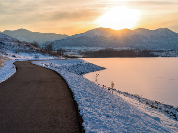 サンセット トレイル - 冷凍山湖沿いの舗装されたハイキング/サイクリング道の冬の夕景。 - denver colorado colorado winter snow ストックフォトと画像