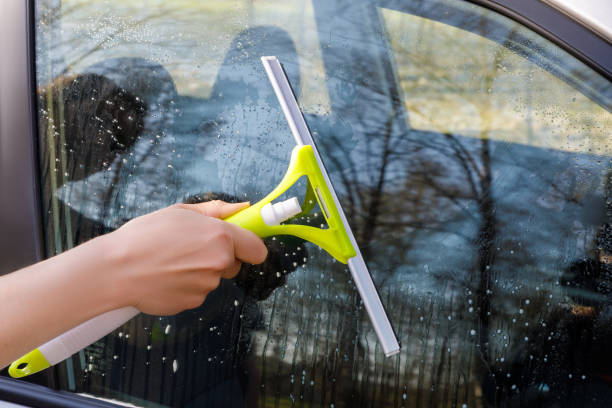 istock Hand washes a window of a car. 950860932