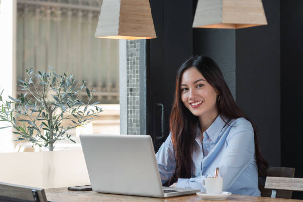 istock Attractive woman with computer in cafeteria 950864252