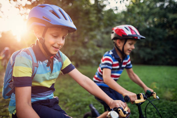 istock Little boys riding bikes in park 950865340