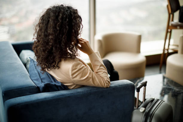 businesswoman sitting in a hotel lobby - airport waiting room waiting airport lounge imagens e fotografias de stock