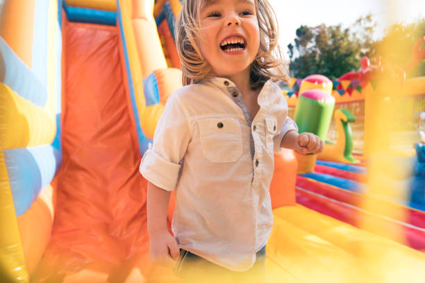 istock Little kid having fun in inflatable castle playground 950866830