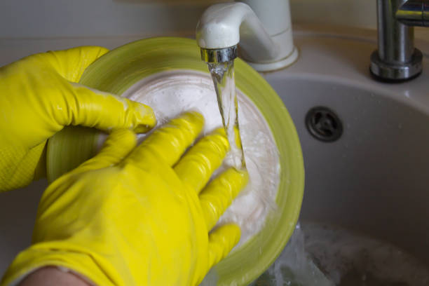 istock Washing dishes in yellow gloves 950876116