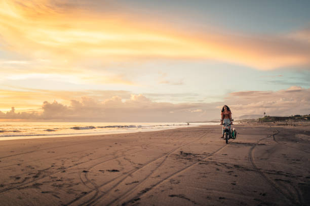 Woman with mountain bike on beach