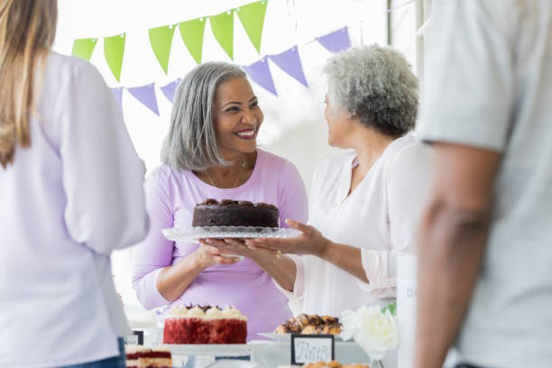 istock Woman donates chocolate cake during bake sale 950886890