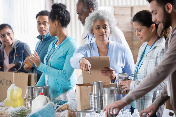 istock Food bank manager instructing volunteers 950887532