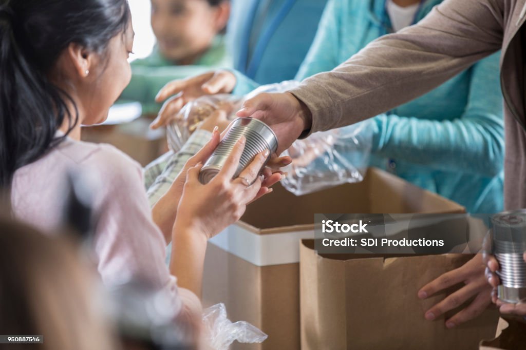 La donna riceve cibo dalla banca del cibo locale - Foto stock royalty-free di Cibo