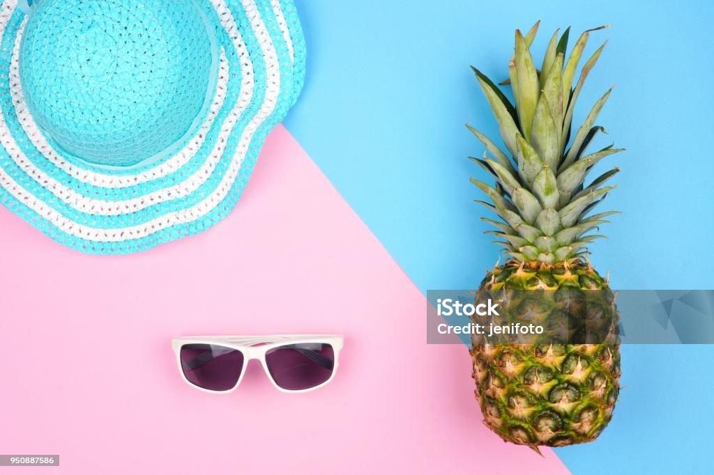 Ananas avec accessoires de mode d’été sur un fond rose et bleu - Photo de Été libre de droits