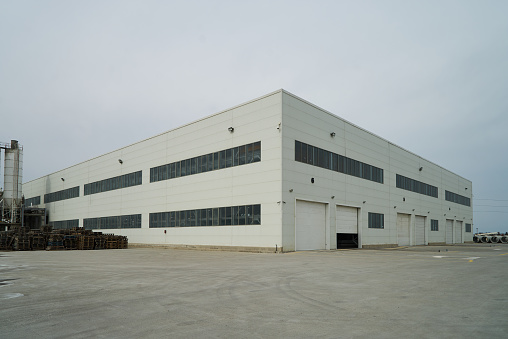 Factory building exterior with warehouse. Industrial production of cement products. Industry manufacturing concept