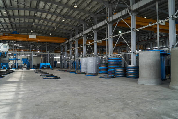 Modern large factory warehouse interior with some goods concrete pipes. Industrial production of cement products. Industry manufacturing concept