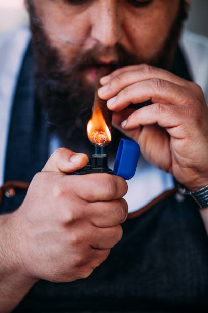 istock Close-up of man's hand with cigar and lighter 950891528