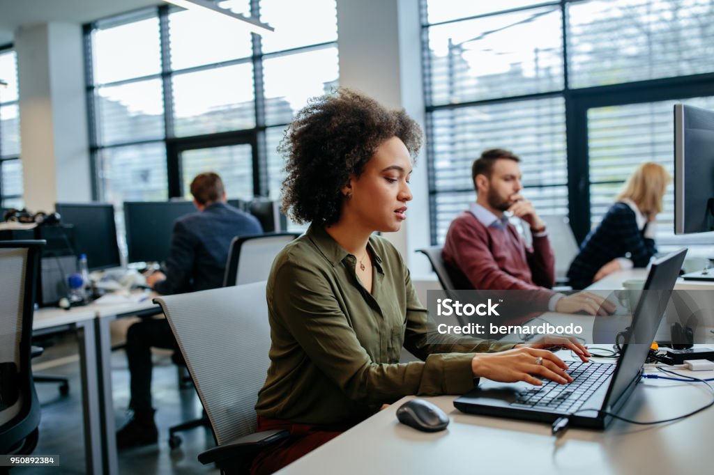 Focused on her work Young businesswoman working on a laptop computer in an office Computer Stock Photo