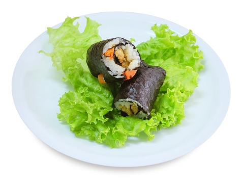 Japanese Cuisine, Traditional Vagetarian Japanese Rice Maki Sushi Roll Stuff with Tofu and Carrot Wrapped in Nori Seaweed Served on Green Oak.