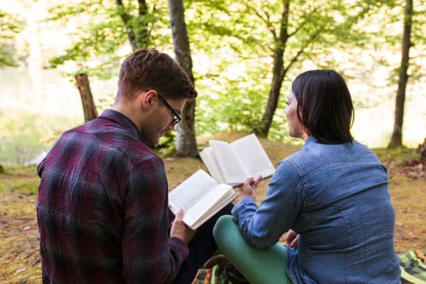 istock Couple Reading a Book On a Picnic 950899432