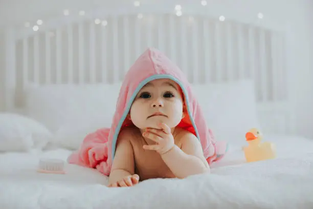 Photo of Baby girl in pink bathrobe