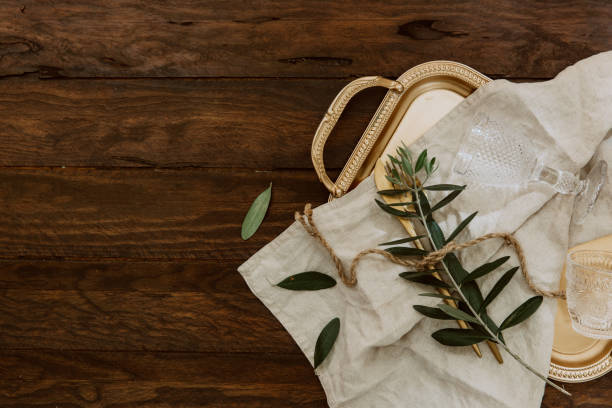 istock Rustic table setting on wooden table: gold vintage silverware, linen napkin and olive brunch. Romantic or wedding concept 950904292
