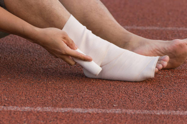 istock Male athlete applying compression bandage onto ankle injury 950904812